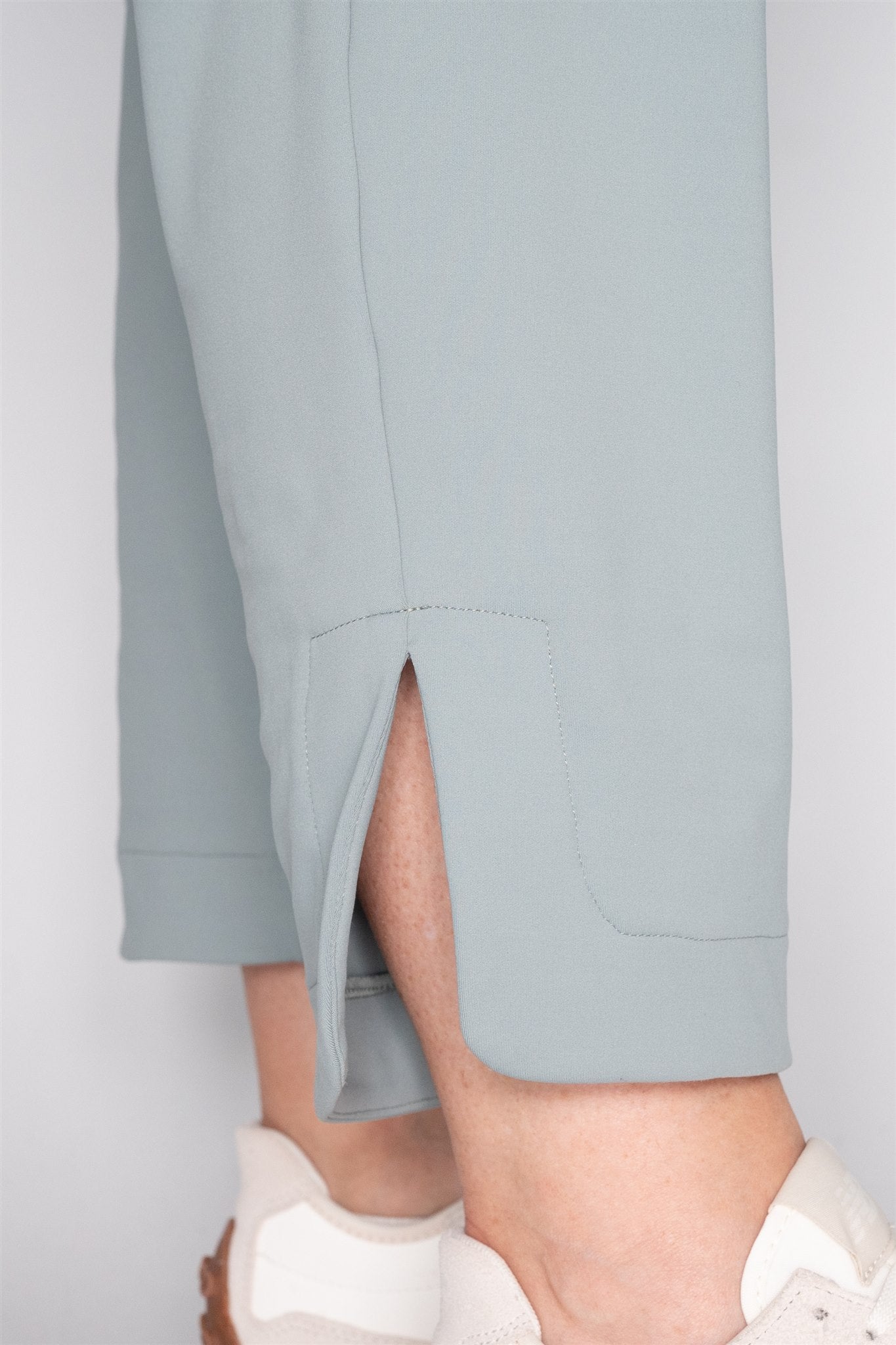 Close-up of Fairway Green ankle pant hem with side vent detail, shown on mid-sized leg. Clean tailoring and breathable flexibility for stylish and active women’s golf wear.