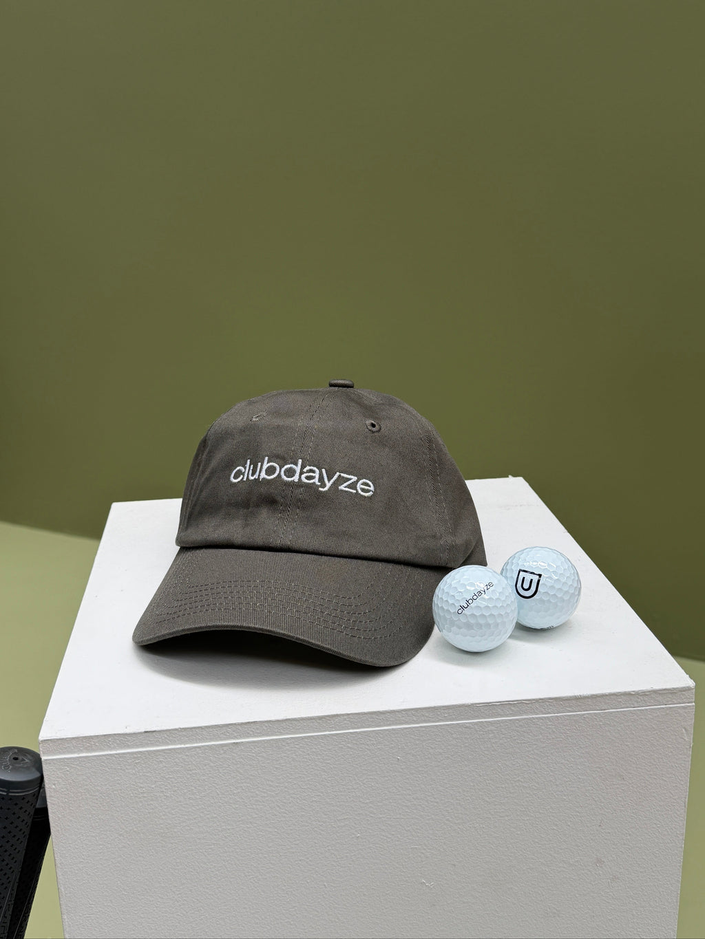 Cotton "Dad hat" with clubdayze logo on the front, clubdayze golf balls next to hat.