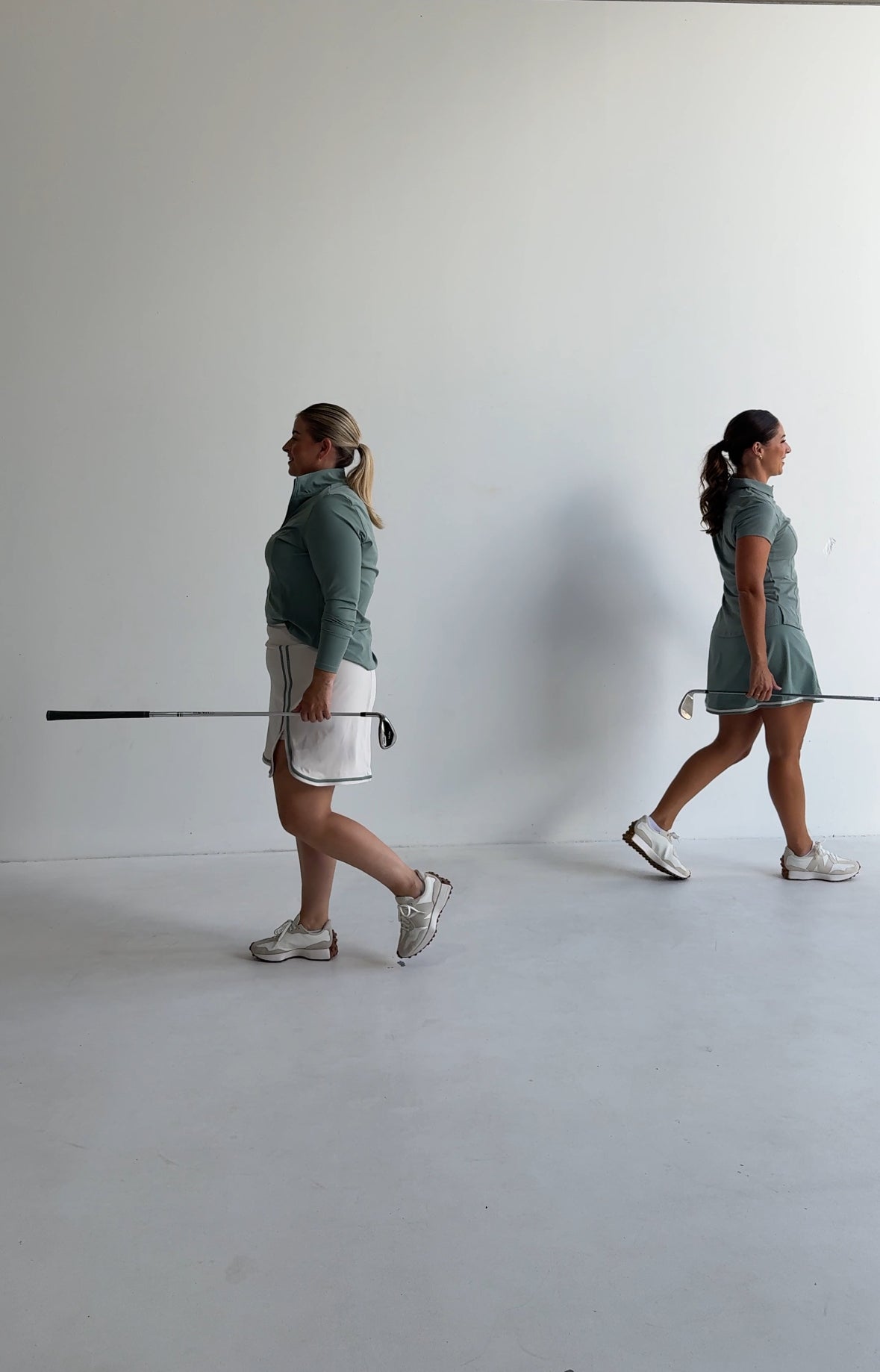 Two women holding golf clubs